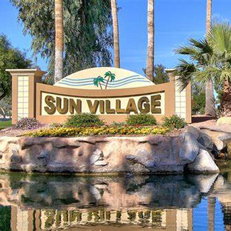 Photo of Sun Village entrance sign, water and palm trees